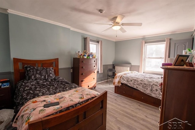 bedroom featuring a ceiling fan, light wood-style flooring, and crown molding