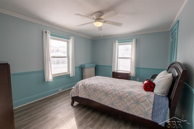 bedroom with baseboards, wood finished floors, a ceiling fan, and crown molding