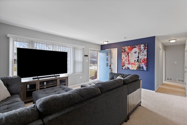 living room with light carpet, visible vents, and baseboards