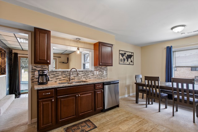 kitchen with tasteful backsplash, baseboards, dark brown cabinets, stainless steel dishwasher, and a sink