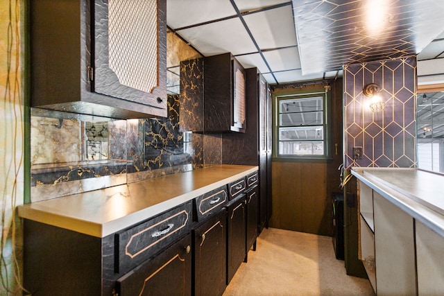 kitchen featuring light countertops, backsplash, a wealth of natural light, and light colored carpet