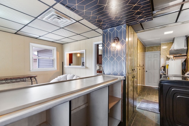 kitchen featuring washer / clothes dryer, visible vents, and stone finish floor