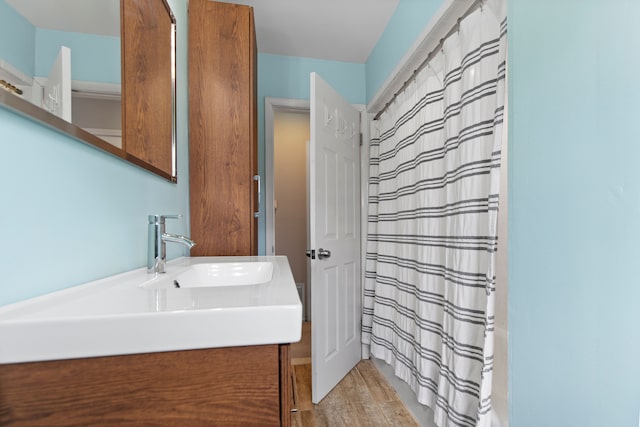 bathroom with a shower with shower curtain, wood finished floors, and vanity