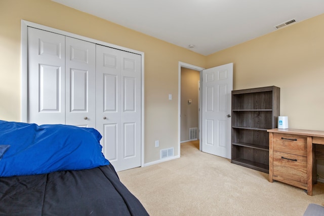 bedroom featuring a closet, visible vents, and light carpet