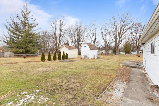 view of yard featuring a shed, fence, and an outdoor structure