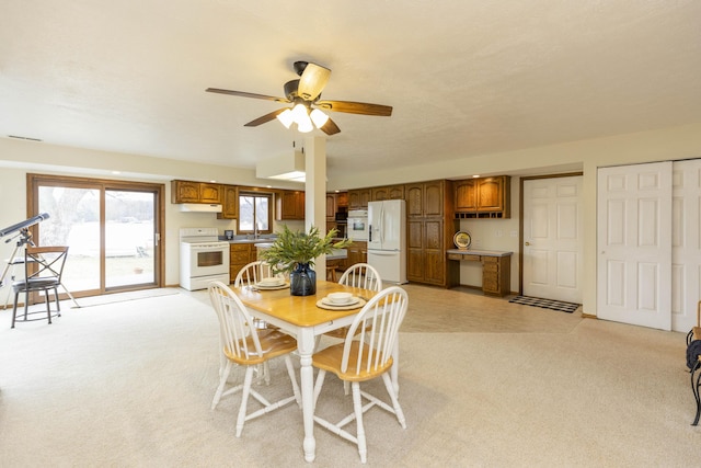 dining space featuring visible vents, a ceiling fan, and light colored carpet