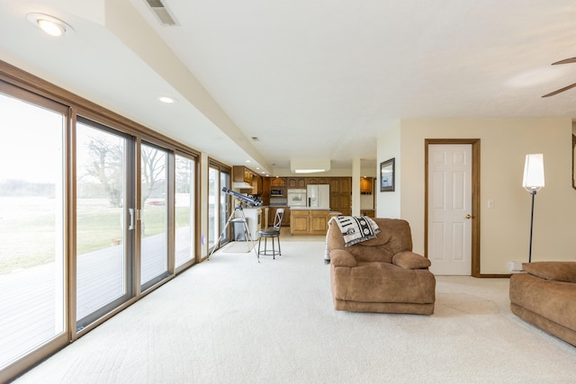 living area with ceiling fan, recessed lighting, light carpet, visible vents, and baseboards