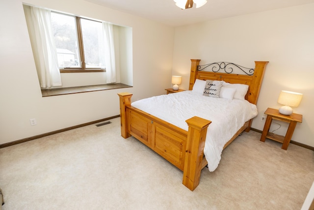 bedroom featuring baseboards, visible vents, and light colored carpet