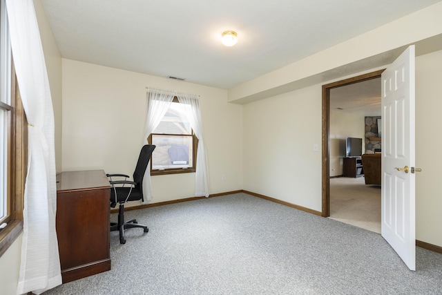 office area featuring baseboards, visible vents, and light colored carpet