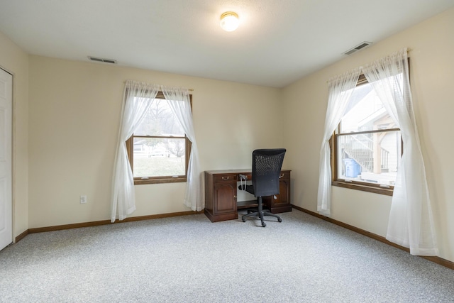 carpeted home office with a wealth of natural light, visible vents, and baseboards