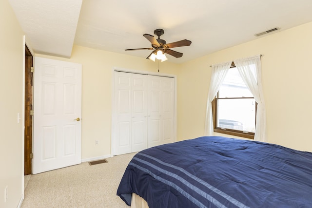 bedroom featuring baseboards, visible vents, light colored carpet, ceiling fan, and a closet