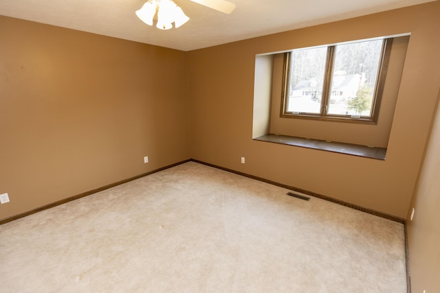 carpeted spare room featuring visible vents and baseboards