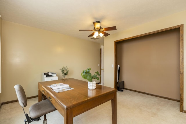 office area featuring light carpet, a ceiling fan, and baseboards