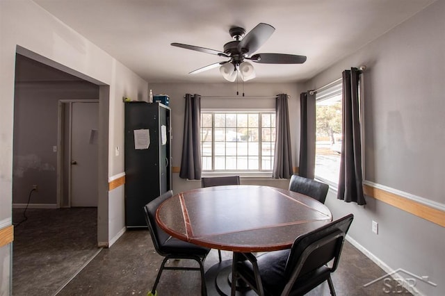 dining area with ceiling fan and baseboards