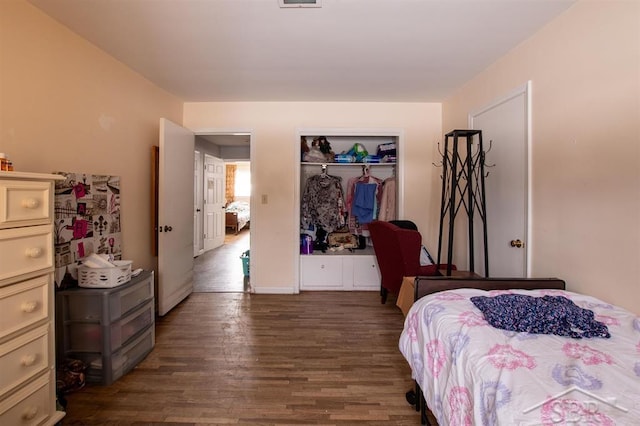 bedroom with dark wood-type flooring and a closet