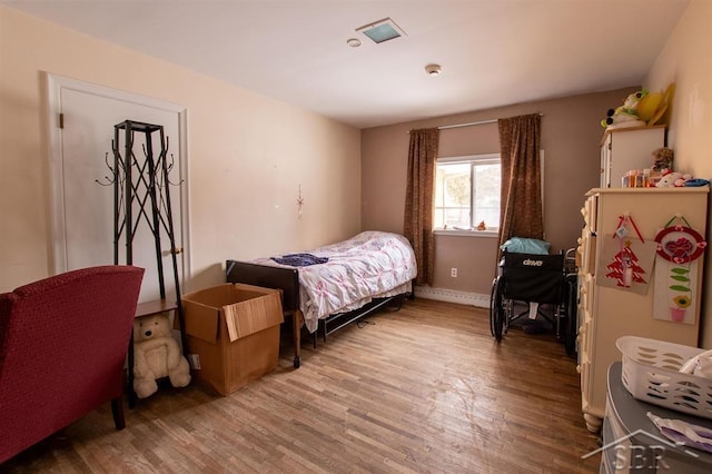 bedroom with wood finished floors and baseboards