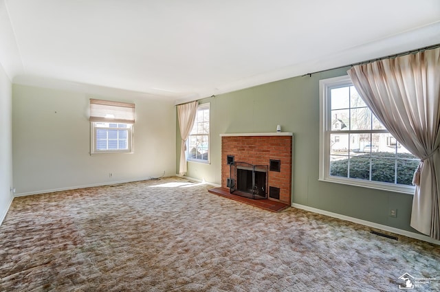 unfurnished living room featuring carpet floors, visible vents, a fireplace, and baseboards