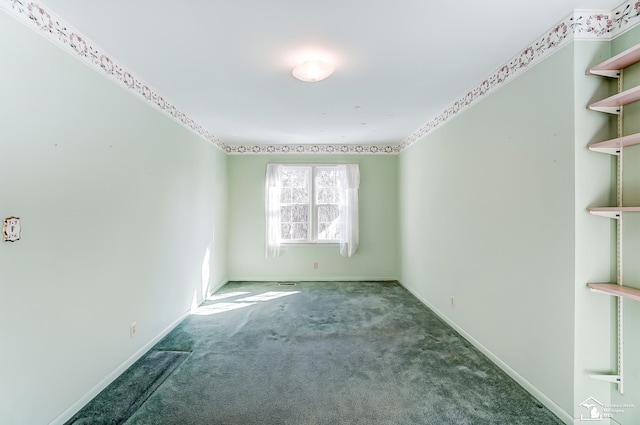 unfurnished room featuring dark carpet and baseboards