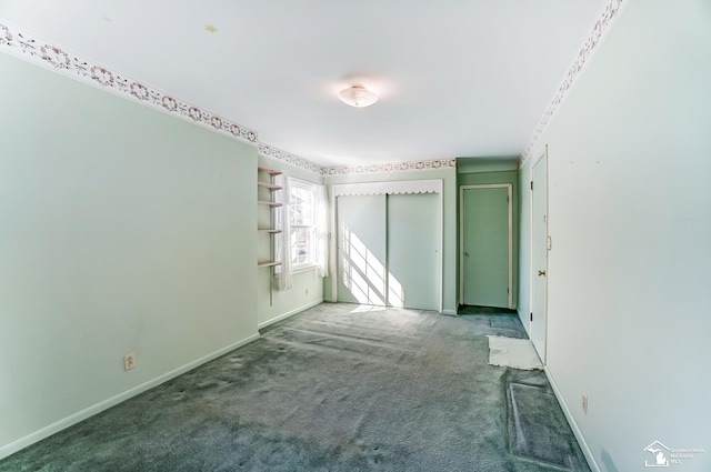 spare room featuring carpet and baseboards