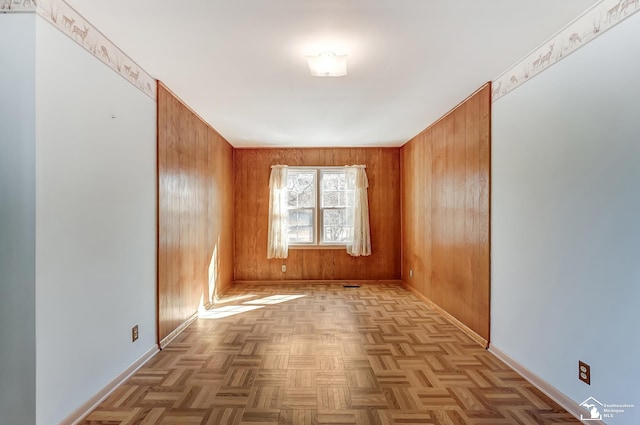 empty room with wood walls and baseboards