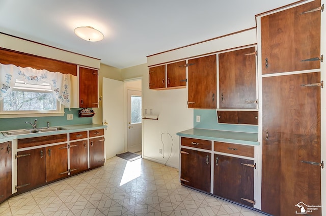 kitchen featuring light floors, light countertops, and a sink