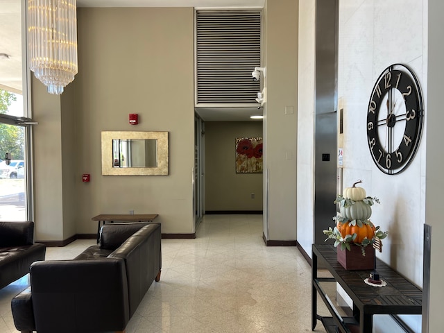 living room with granite finish floor, baseboards, and a notable chandelier