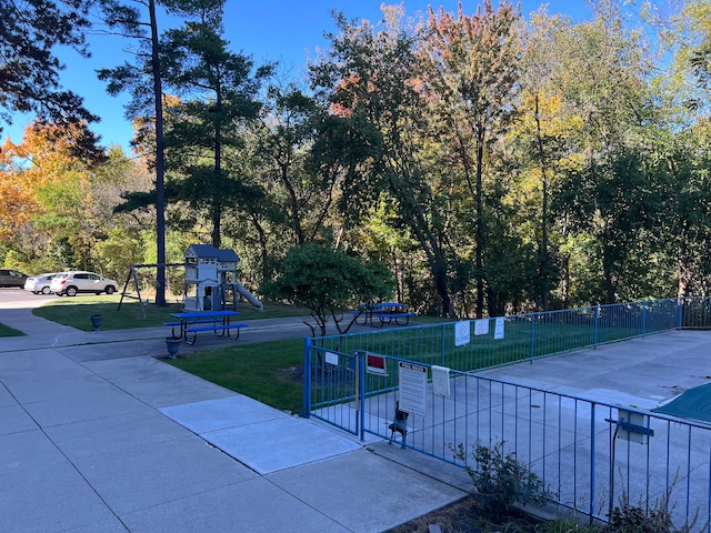 surrounding community with fence, playground community, and a yard