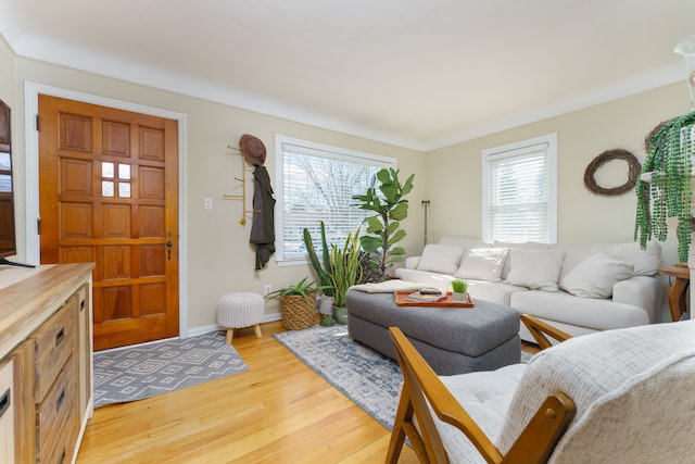 living area featuring light wood-style floors and baseboards