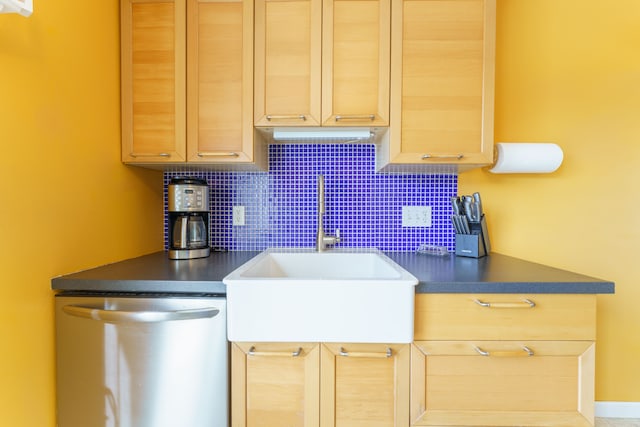 kitchen with a sink, dark countertops, tasteful backsplash, and dishwasher