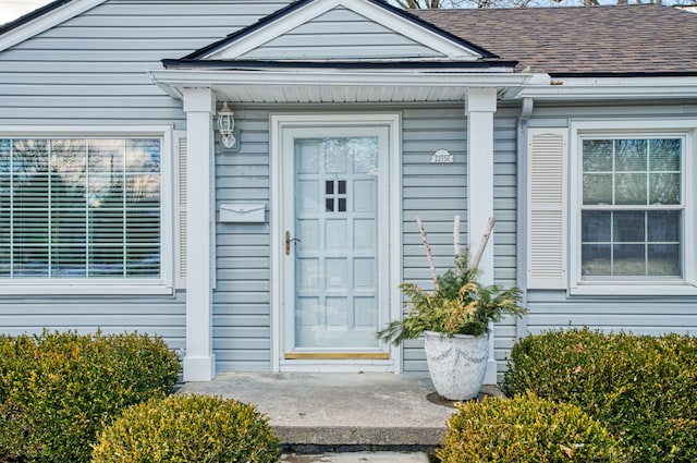 entrance to property with roof with shingles