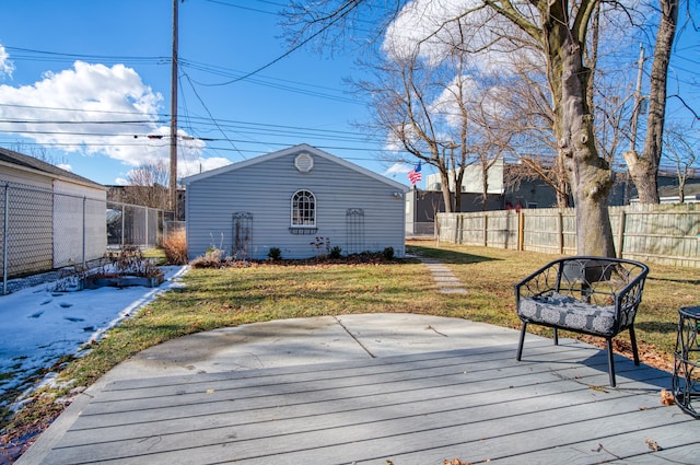 wooden deck featuring fence, a lawn, and an outbuilding