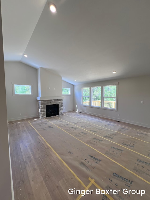 1910 Fallasburg Park Dr NE Unit 5, Lowell, MI 49331 - unfurnished living room featuring vaulted ceiling, recessed lighting, hardwood / wood-style flooring, a fireplace, and baseboards