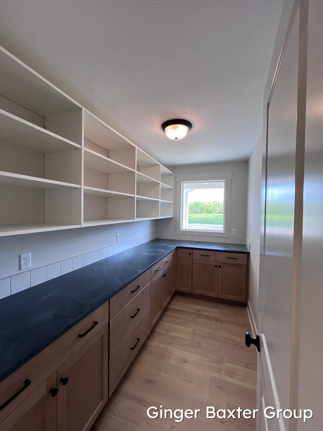 1910 Fallasburg Park Dr NE Unit 5, Lowell, MI 49331 - kitchen with open shelves, light wood-style floors, dark countertops, and baseboards