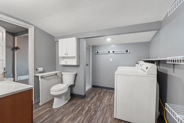 full bath featuring toilet, wood finished floors, vanity, baseboards, and washer and clothes dryer