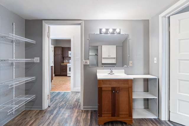 bathroom with baseboards, wood finished floors, and vanity