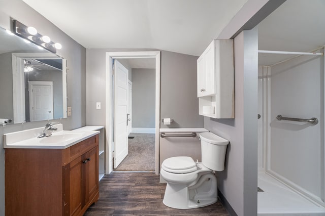 bathroom featuring a shower, vanity, toilet, and wood finished floors