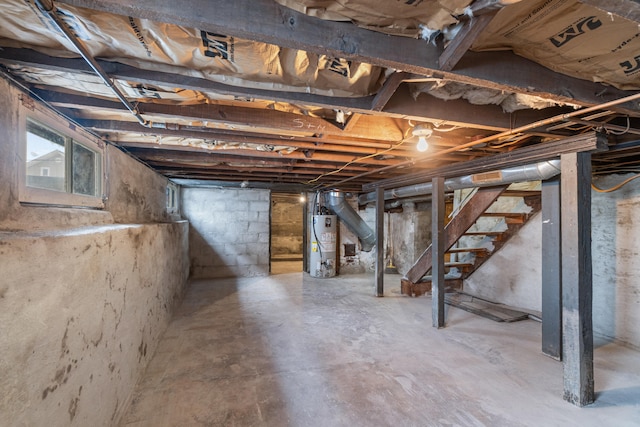 basement featuring gas water heater and stairs