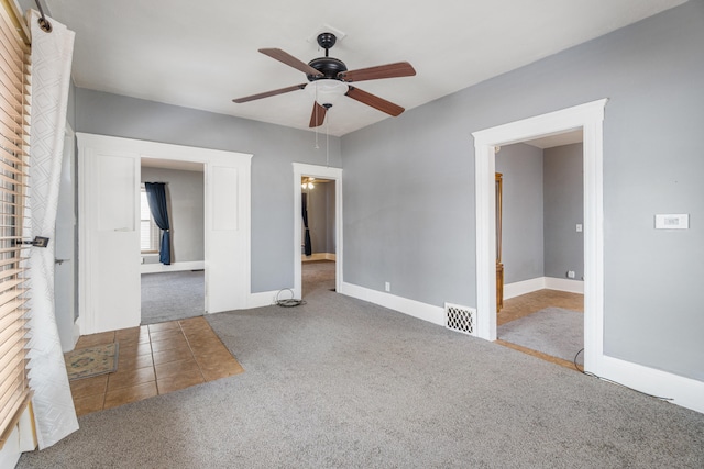 unfurnished bedroom featuring carpet floors, baseboards, visible vents, and a ceiling fan