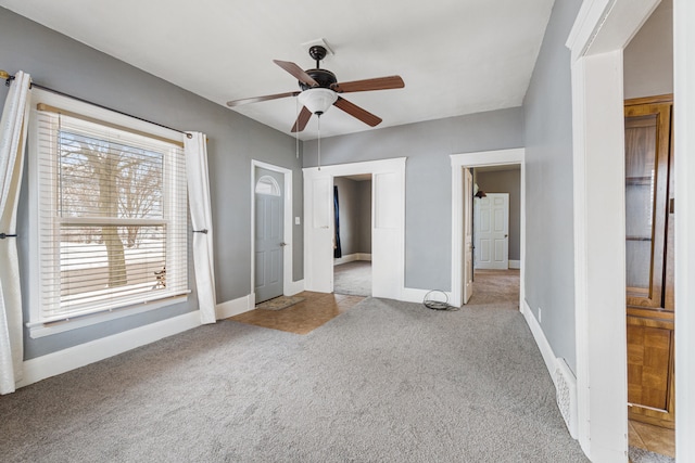 unfurnished bedroom with light carpet, ceiling fan, and baseboards