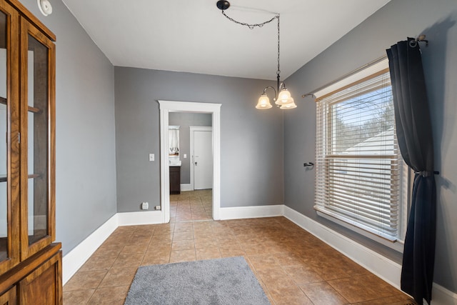 dining space featuring baseboards, a chandelier, and light tile patterned flooring