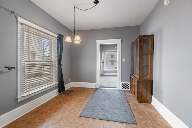 interior space with a chandelier, visible vents, baseboards, and light tile patterned floors