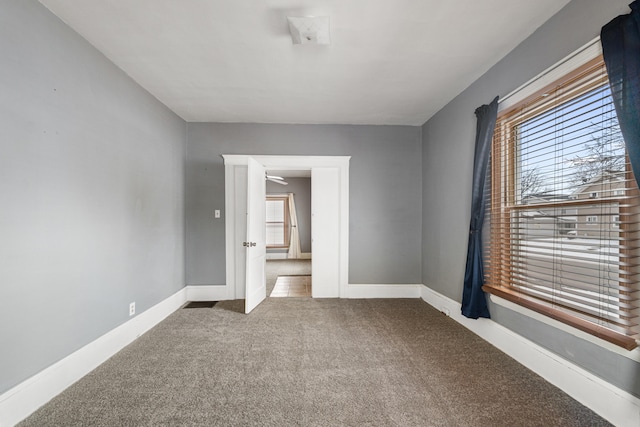 spare room featuring carpet and baseboards