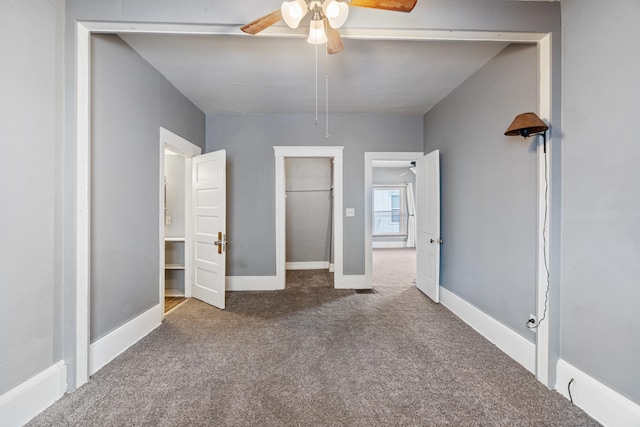 unfurnished bedroom with visible vents, a ceiling fan, attic access, carpet flooring, and baseboards