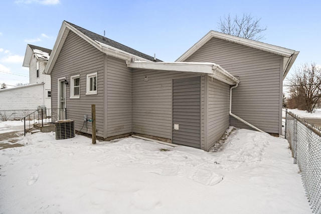 snow covered rear of property with fence