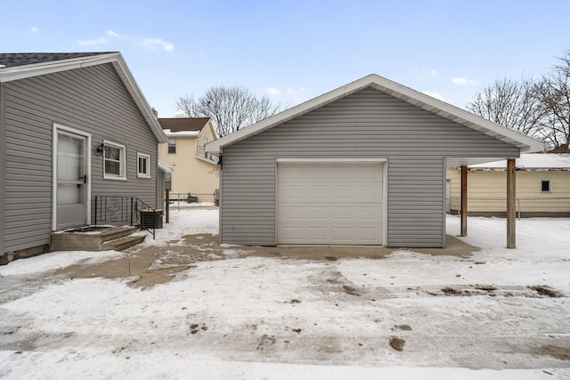 snow covered garage with a detached garage