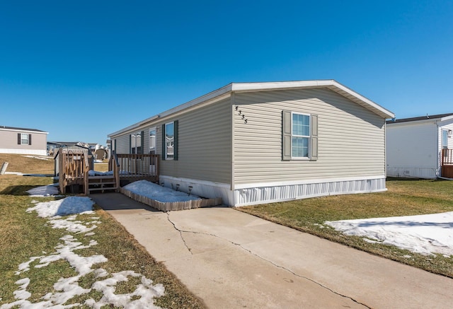 view of side of home with a lawn and a wooden deck