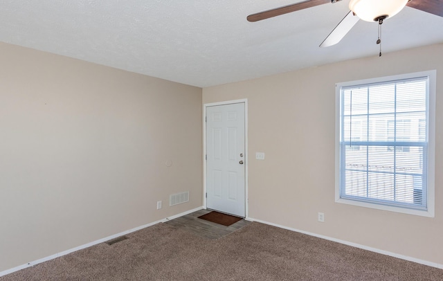 carpeted empty room with plenty of natural light, visible vents, and baseboards