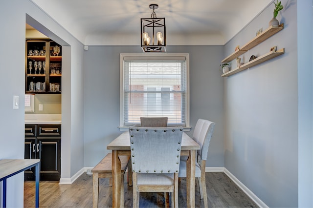 dining area with a notable chandelier, baseboards, and wood finished floors