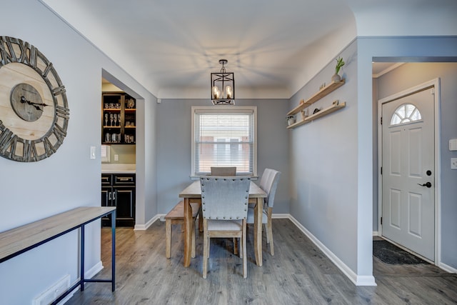 dining room featuring baseboards, a chandelier, and wood finished floors