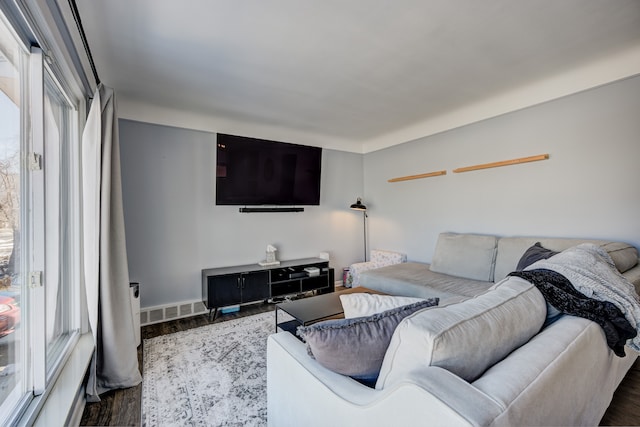 living area featuring visible vents and wood finished floors